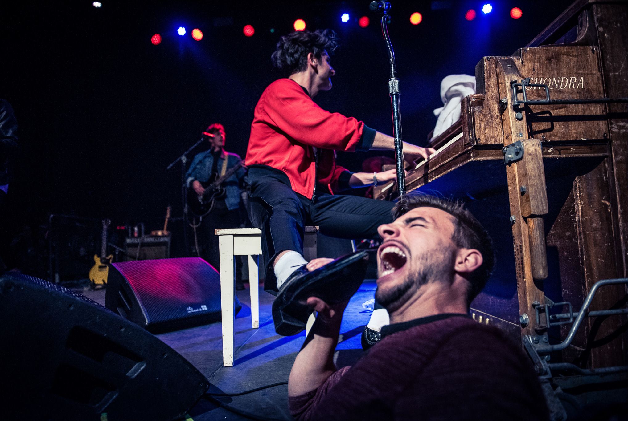 Pianist mid-song with a fan singing along in the foreground